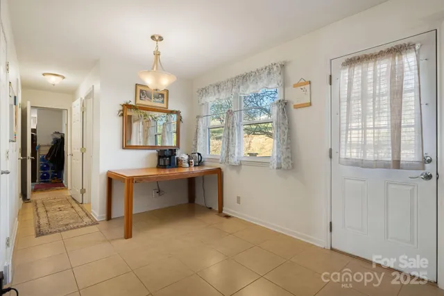 a large white kitchen with granite countertop a sink and dishwasher with a large window