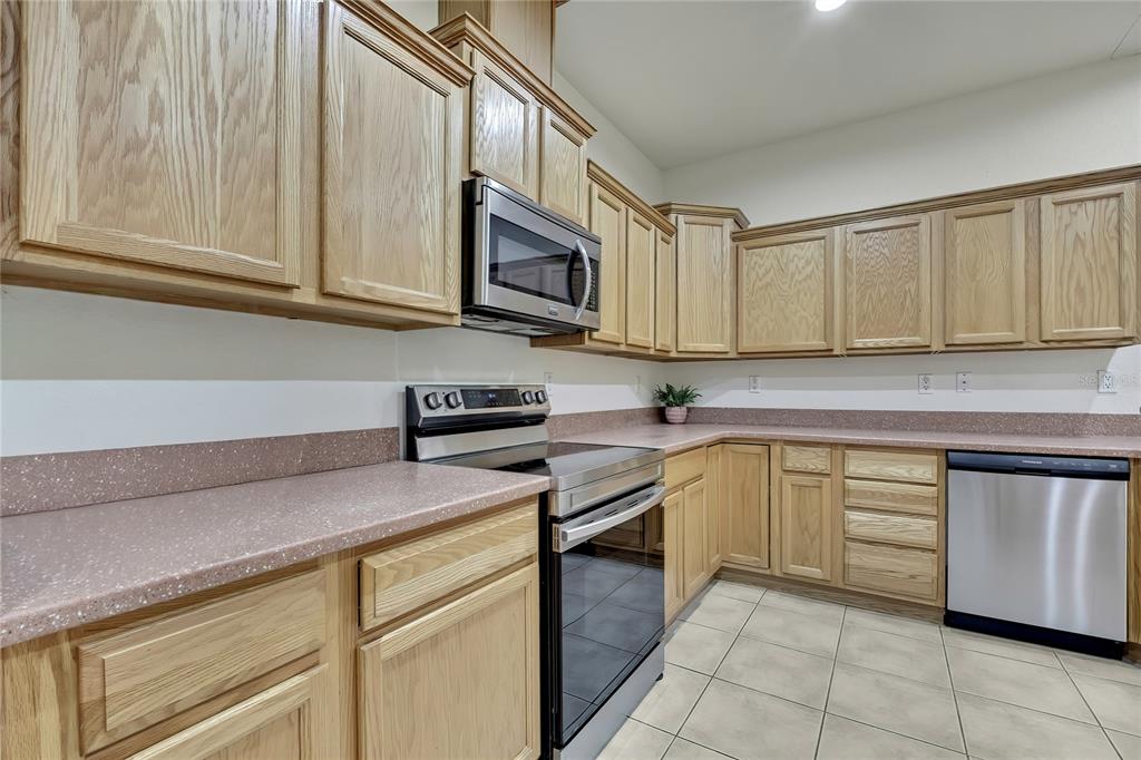 12052 Jade Avenue Spring Hill, FL 34609 - Photo 11 of 45 a kitchen with stainless steel appliances granite countertop a sink and a stove
