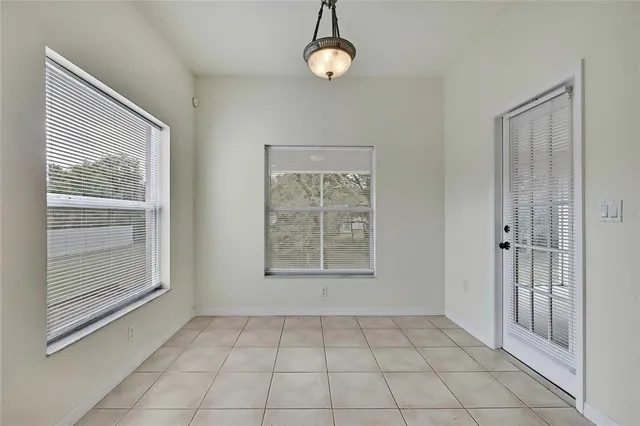 a view of a hallway with wooden floor and a bathroom