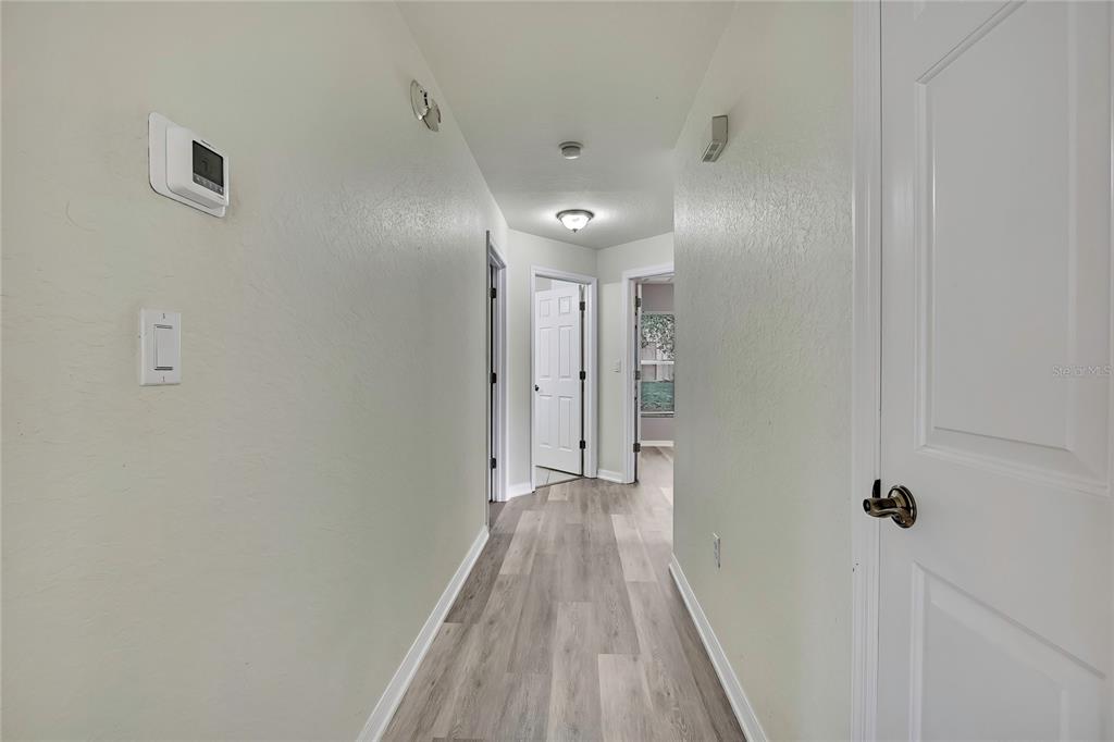 12052 Jade Avenue Spring Hill, FL 34609 - Photo 14 of 45 a view of a hallway with wooden floor and a bathroom