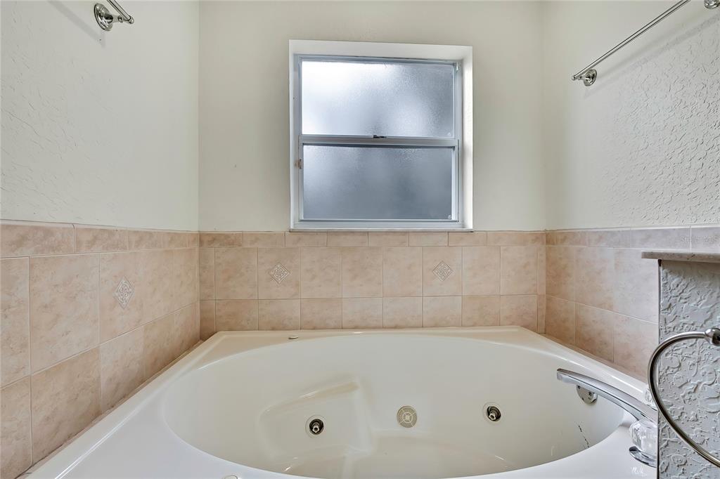 12052 Jade Avenue Spring Hill, FL 34609 - Photo 20 of 45 a bathroom with a tub and a shower