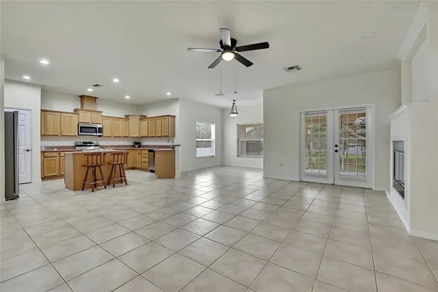 a kitchen with stainless steel appliances kitchen island granite countertop a refrigerator and a sink