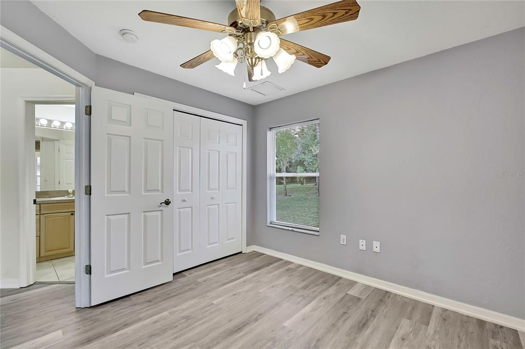 12052 Jade Avenue Spring Hill, FL 34609 - Photo 29 of 45 an empty room with wooden floor fan and windows