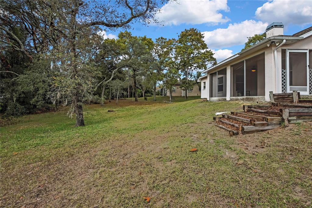 12052 Jade Avenue Spring Hill, FL 34609 - Photo 35 of 45 a view of a backyard with a garden and trees