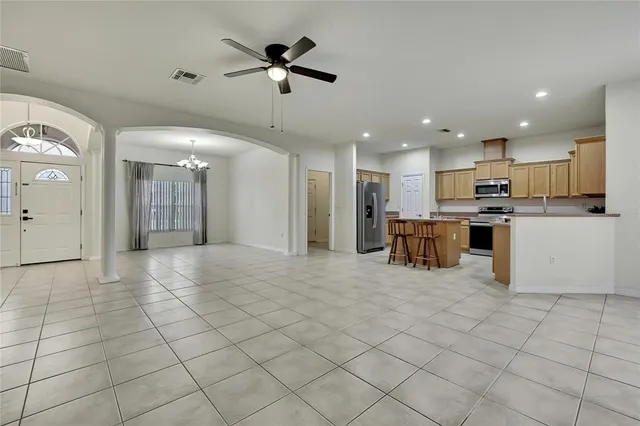 a view of kitchen with stainless steel appliances kitchen island granite countertop a refrigerator and a stove top oven