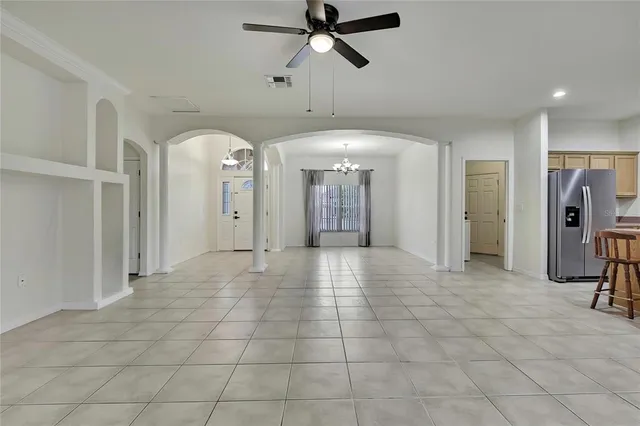 a view of a hallway with closet and a chandelier fan