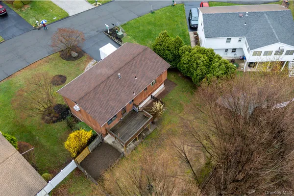 an aerial view of a house with yard and trees