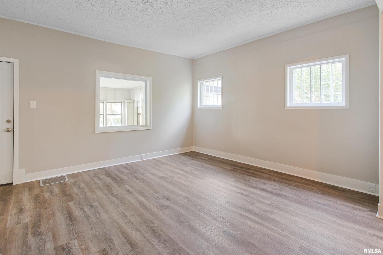 208 South 10th Street Herrin, IL 62948 - Photo 14 of 24 a view of an empty room with wooden floor and a window