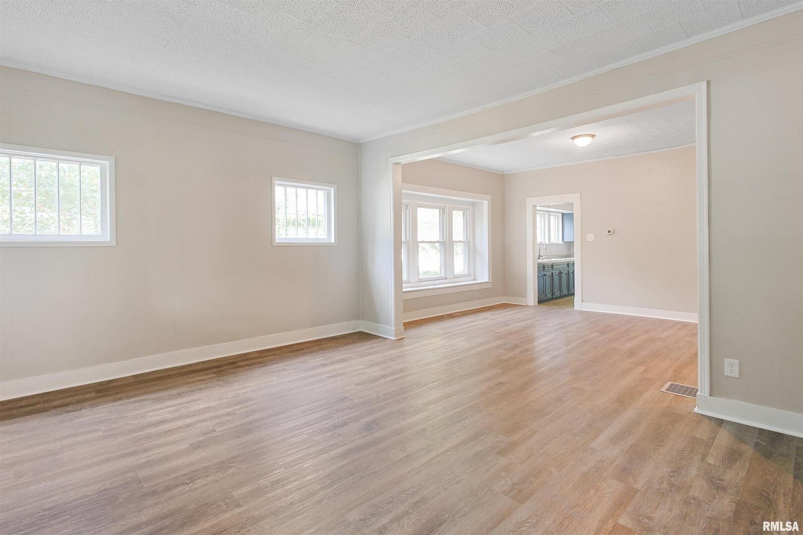 208 South 10th Street Herrin, IL 62948 - Photo 3 of 24 a view of an empty room with wooden floor and windows
