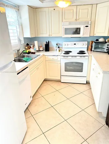 a kitchen with a stove a sink dishwasher and a refrigerator