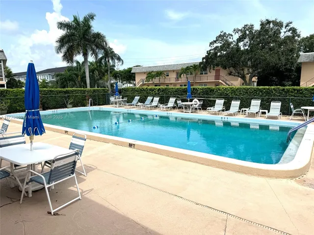 a view of a swimming pool with a patio and a garden