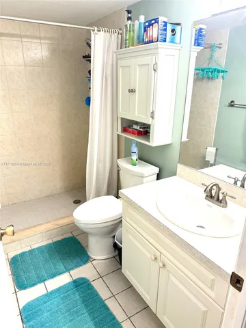 a bathroom with a sink a toilet and shower curtain