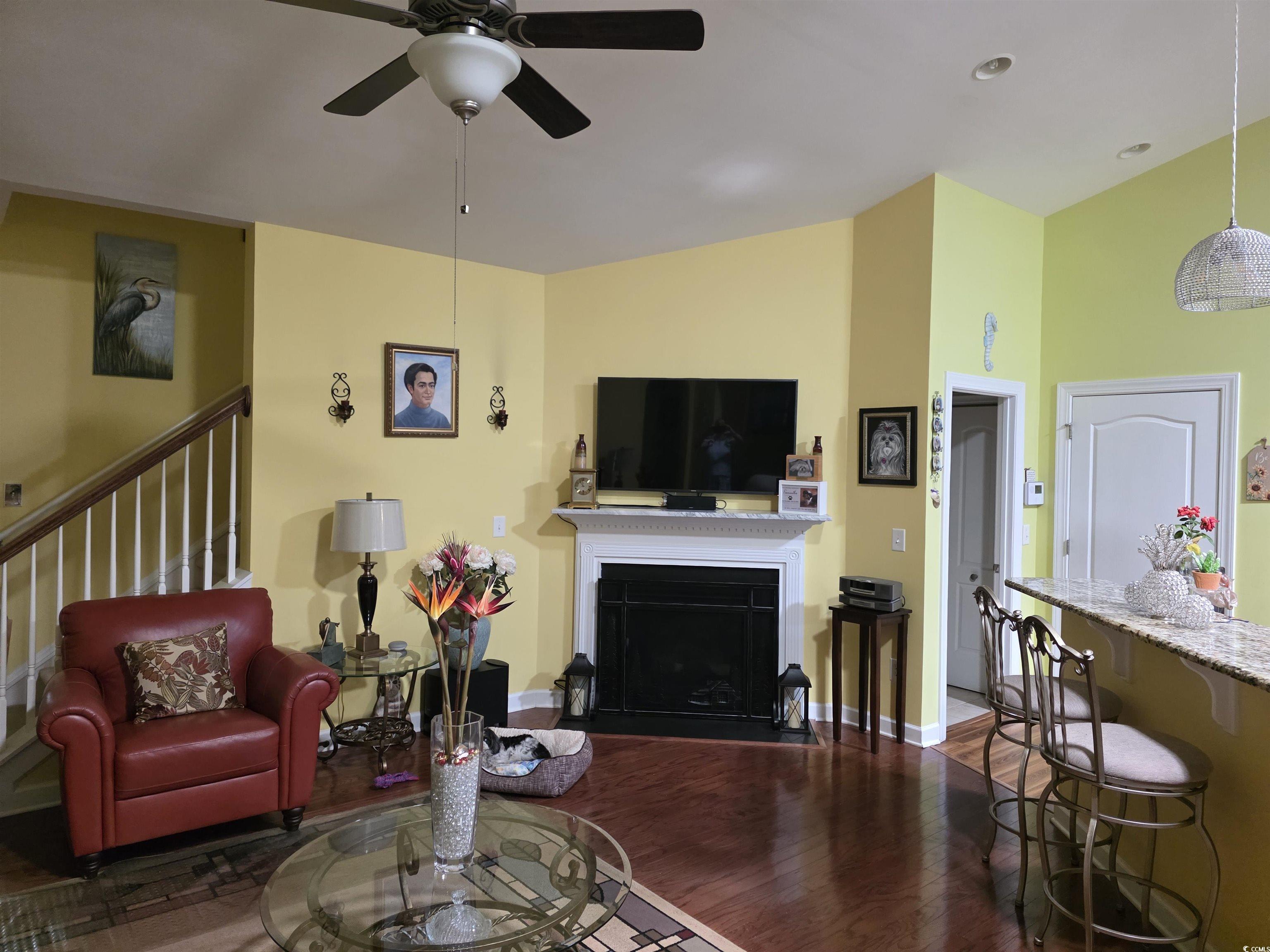 1575 Berkshire Avenue Myrtle Beach, SC 29577 - Photo 13 of 30 Living room with dark wood-style floors, a fireplace with raised hearth, and ceiling fan
