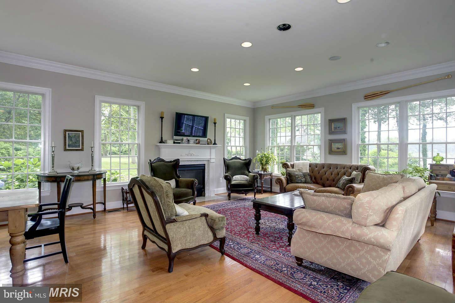 733 Whitehall Plains Road Annapolis, MD 21409 - Photo 4 of 18 a living room with furniture a fireplace a flat screen tv and windows