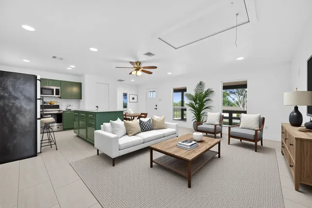 a living room with furniture kitchen view and a chandelier