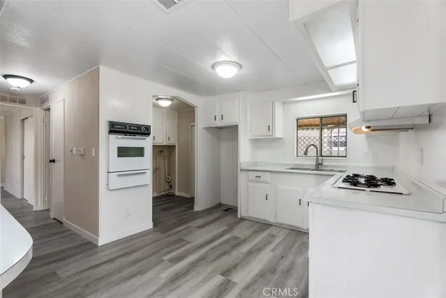a kitchen with granite countertop white cabinets and white appliances