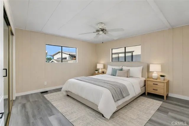 an empty room with a chandelier fan and wooden floor