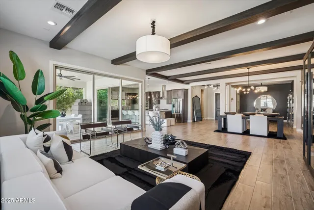 a living room with furniture a flat screen tv and a chandelier