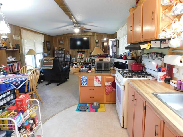 a open kitchen with stainless steel appliances kitchen island granite countertop a sink dishwasher stove and cabinets