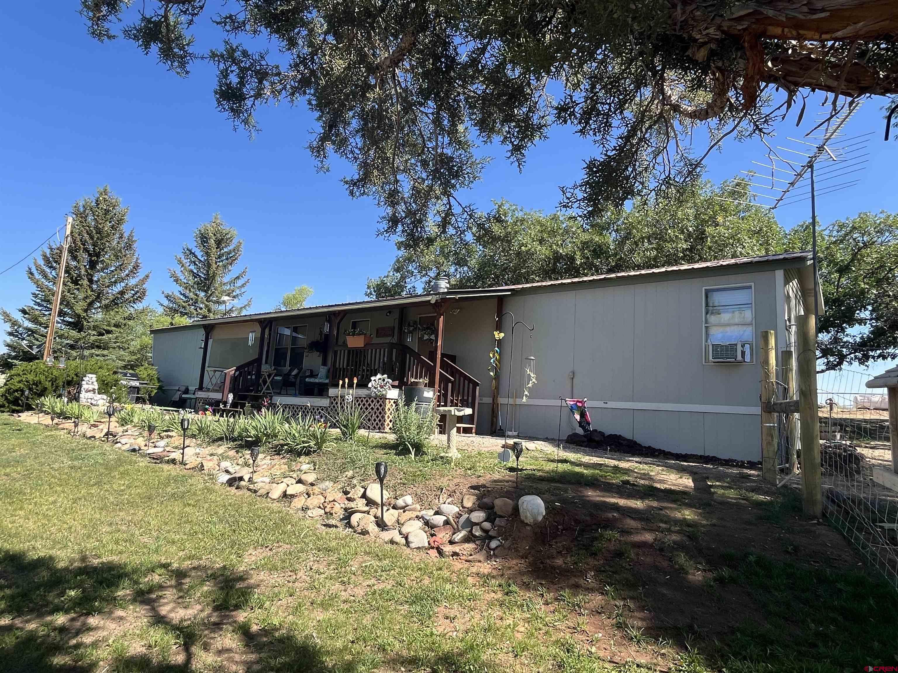 23300 Rd X Lewis, CO 81327 - Photo 33 of 44 a backyard of a house with table and chairs under an umbrella