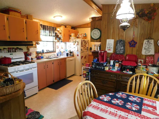 a kitchen filled with stainless steel appliances kitchen island granite countertop a stove a sink and a dining table