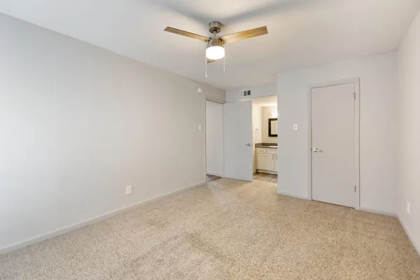 an empty room with a white walls and ceiling fan