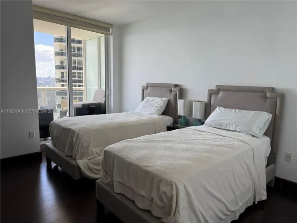 a bedroom with two beds and a large window