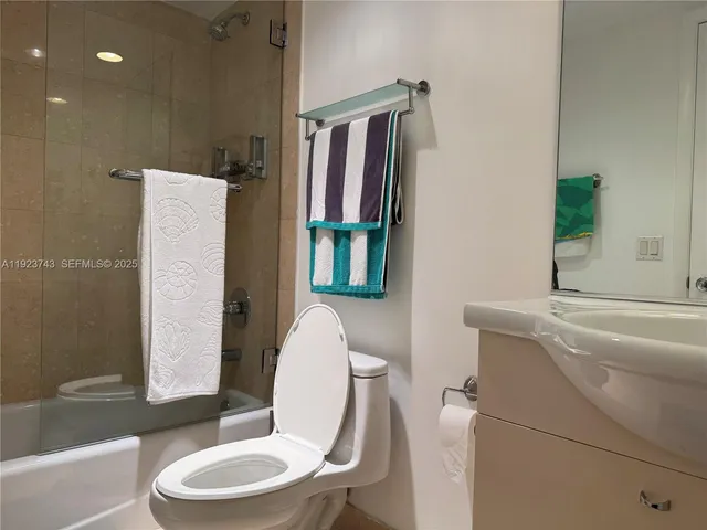 a bathroom with a granite countertop toilet sink and mirror