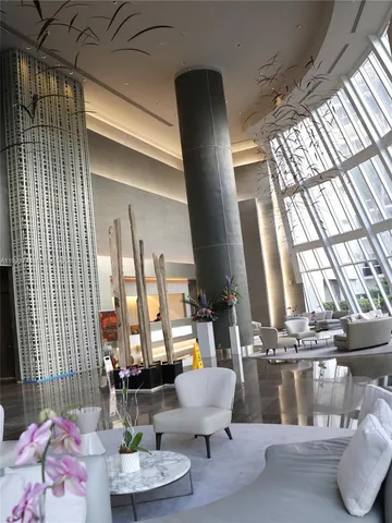 a living room with furniture and floor to ceiling windows