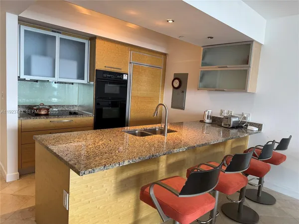 a kitchen with granite countertop a sink and a stove