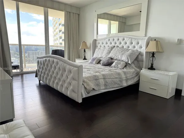 a bedroom with a bed and a couch next to a window