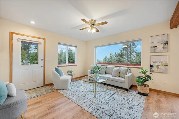 a kitchen with stainless steel appliances granite countertop a sink a stove a refrigerator cabinets and living room view