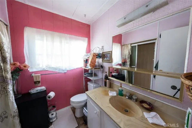 a bathroom with a sink mirror vanity and toilet