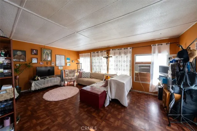 a living room with furniture a flat screen tv and floor to ceiling window