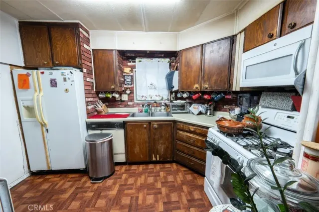 a kitchen with stainless steel appliances granite countertop a refrigerator stove and sink