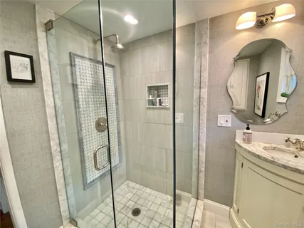 a bathroom with a double vanity sink mirror and shower