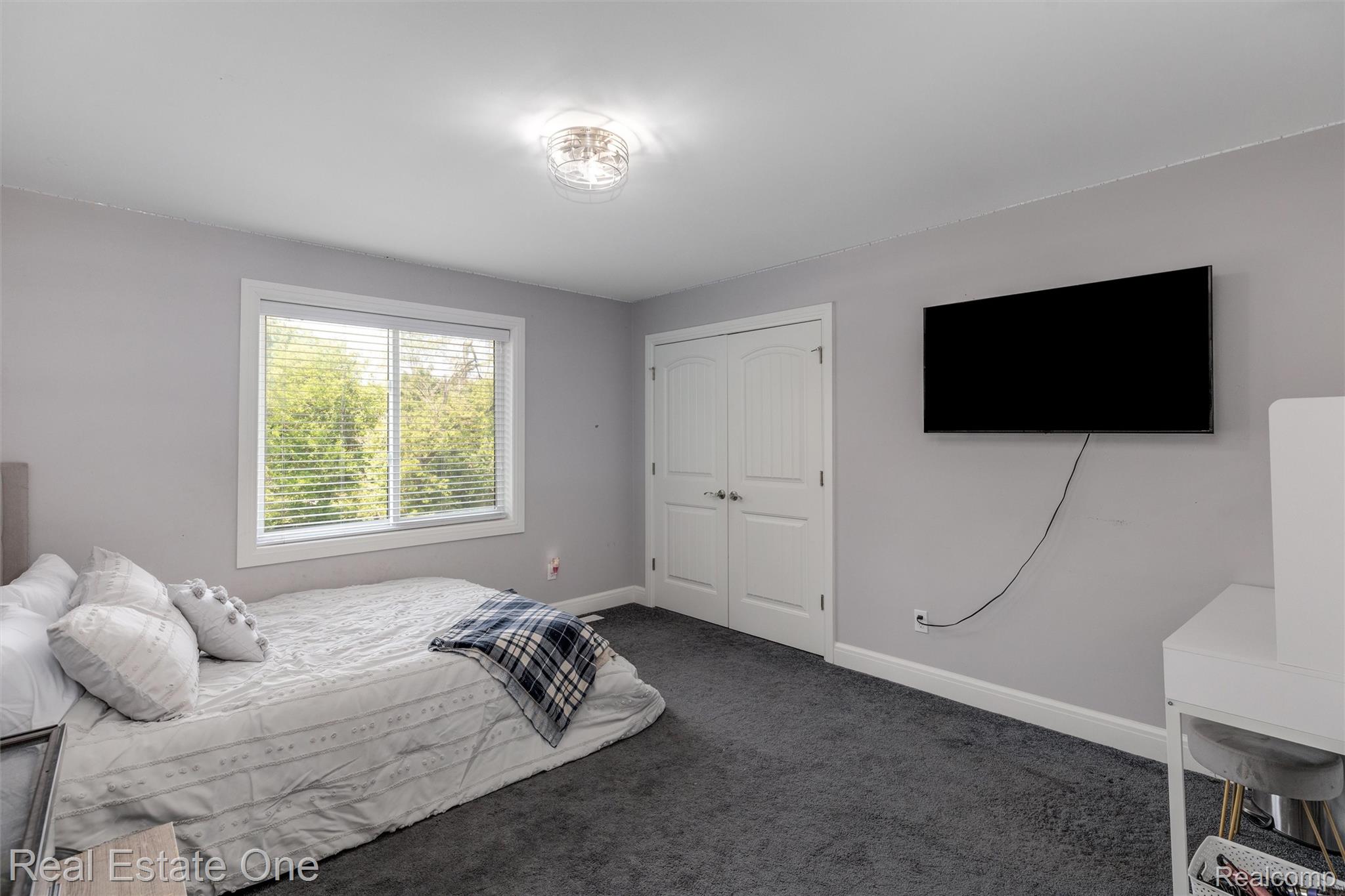 2983 28 Mile Road Washington, MI 48094 - Photo 24 of 54 Carpeted room featuring a large window with blinds, white trim, a double-door closet, and a flush-mount ceiling light