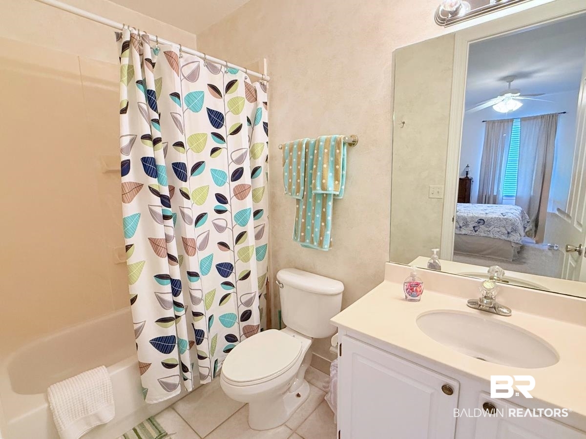 27284 Gulf Road, Unit 212 Orange Beach, AL 36561 - Photo 19 of 35 Full bathroom with shower / bath combo, vanity, ceiling fan, and light tile patterned floors