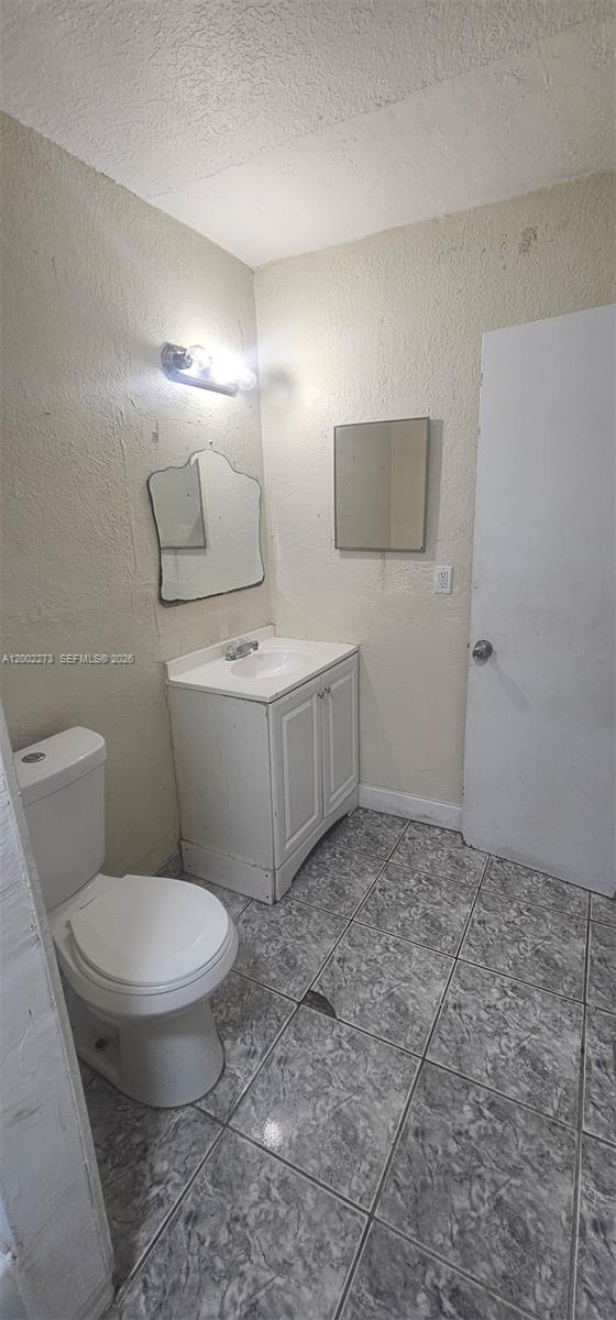3932 Northwest 207 St Road Miami Gardens, FL 33055 - Photo 15 of 19 a bathroom with a toilet a sink and mirror
