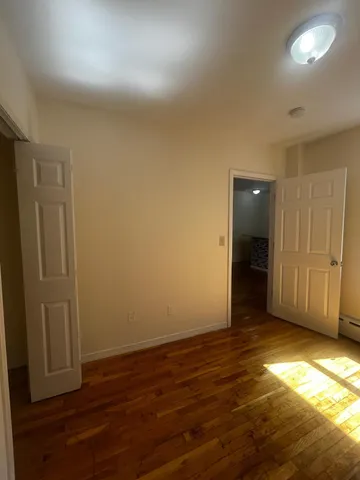 an empty room with wooden floor and entrance