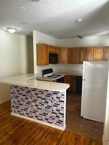 a kitchen with granite countertop a stove a sink and a refrigerator