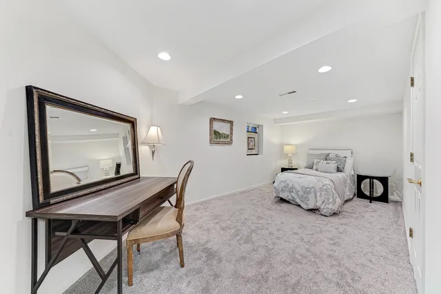 a bedroom with a bed and a dresser with mirror