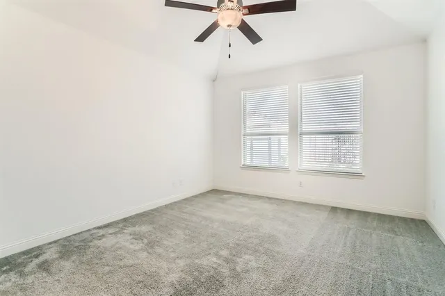 an empty room with a ceiling fan and closet