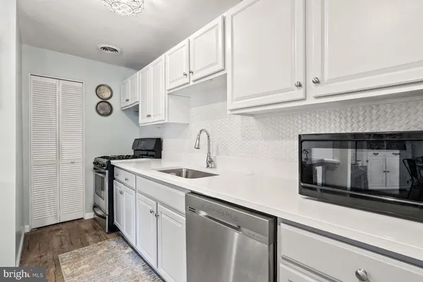 a kitchen with stainless steel appliances granite countertop a sink a stove and cabinets