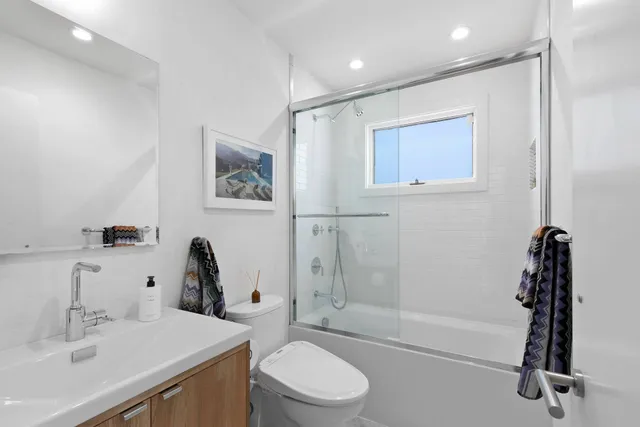 a bathroom with a sink a toilet and shower