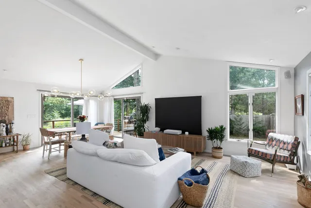 a living room with furniture a flat screen tv and a large window