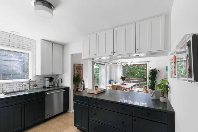 a kitchen with stainless steel appliances granite countertop a sink a stove and a refrigerator