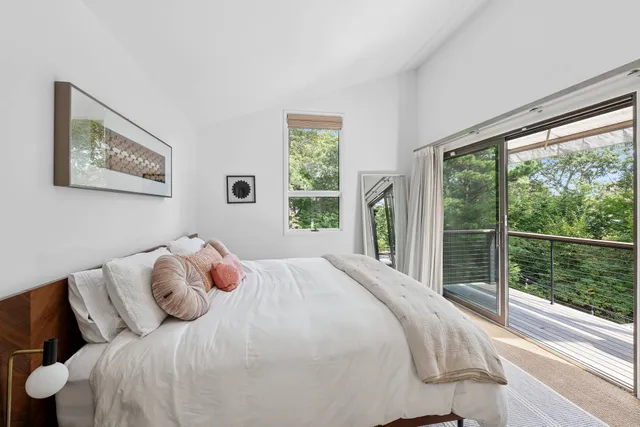 a bedroom with a bed and a large window