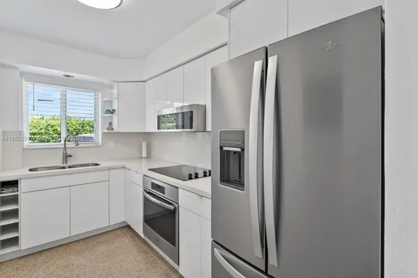 a kitchen with stainless steel appliances granite countertop a refrigerator sink and stove