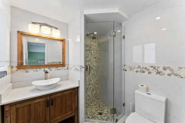 a bathroom with a sink a toilet and shower